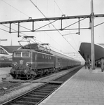 155004 Afbeelding van de electrische locomotief nr. 1125 (serie 1100) van de N.S. met rijtuigen plan E langs een perron ...